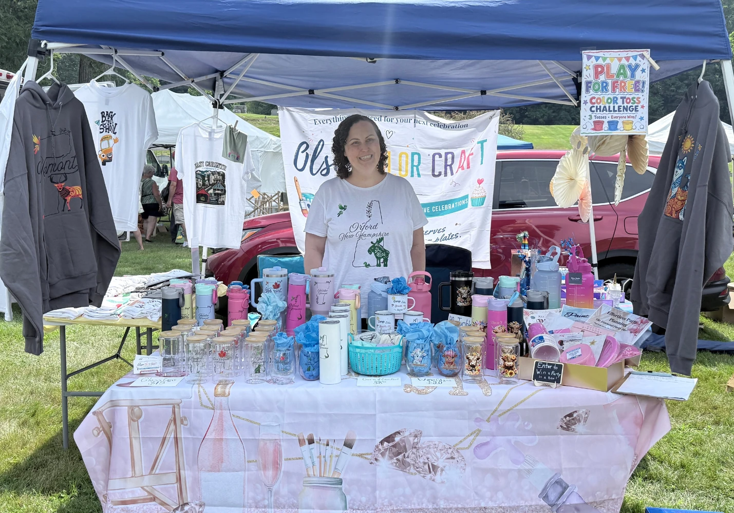 Olsen Colorcraft Co. craft fair booth with handmade drinkware, apparel and gifts