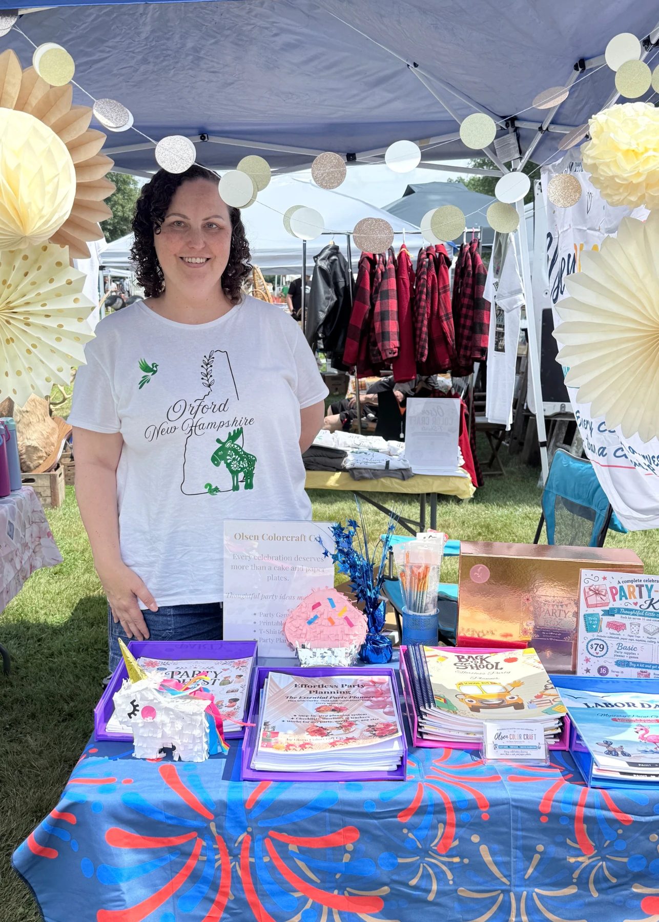 Shannon at the Olsen Colorcraft Co. craft fair booth with celebration planners and games