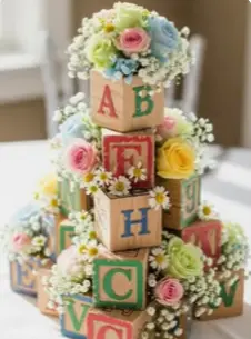 Blocks baby shower inspiration — stacked ABC letter blocks wrapped in fresh flowers as a centerpiece