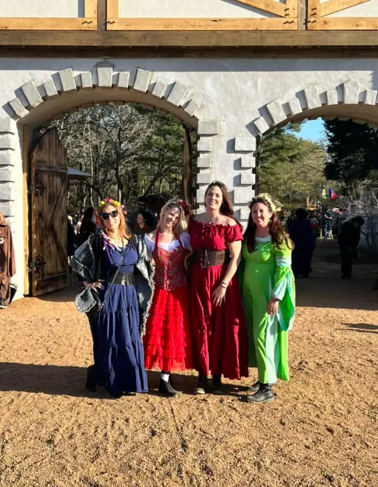 Real enchanted forest party — woman in red renaissance dress against ivy wall