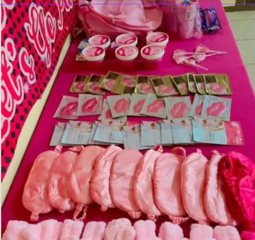 Spa day inspiration — flat lay of spa party favors including lip masks, eye masks, and headbands on a pink table