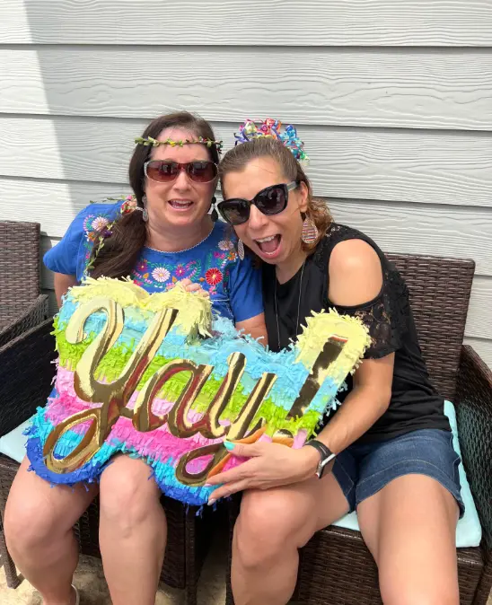 Real adult piñata party — two women holding colorful Yay piñata