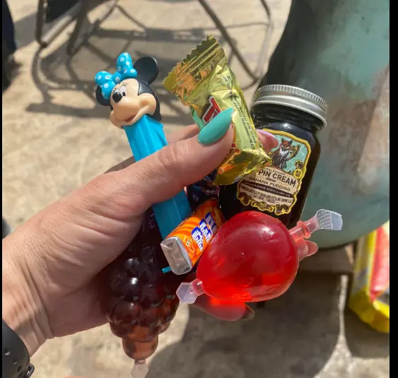 Real adult piñata party — hand holding piñata fillers including mini bottles