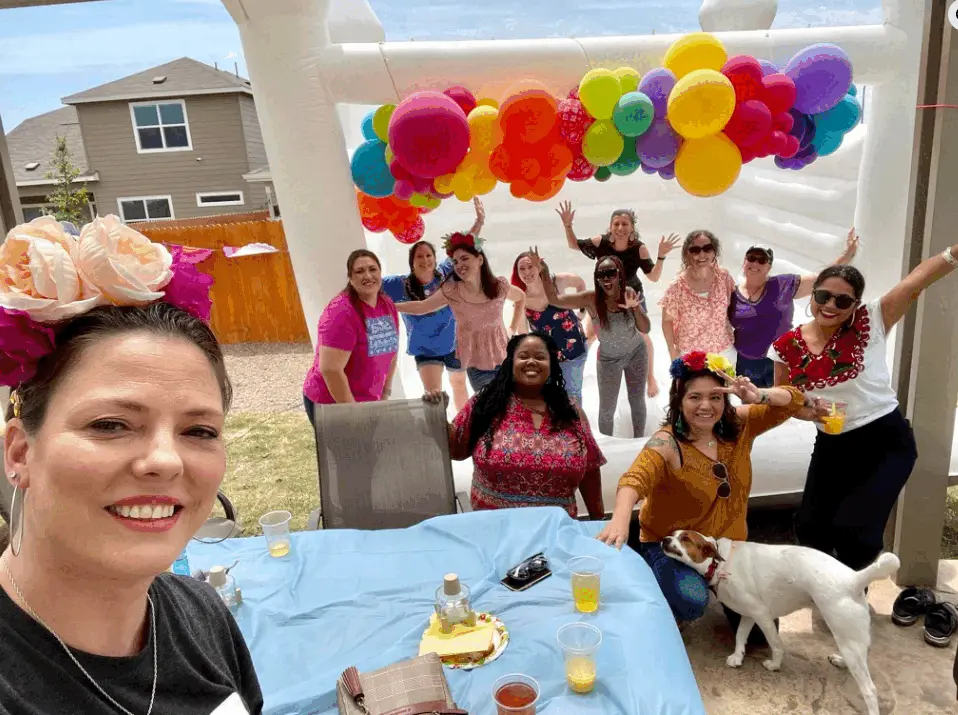Real adult piñata party — group of women under rainbow balloon arch