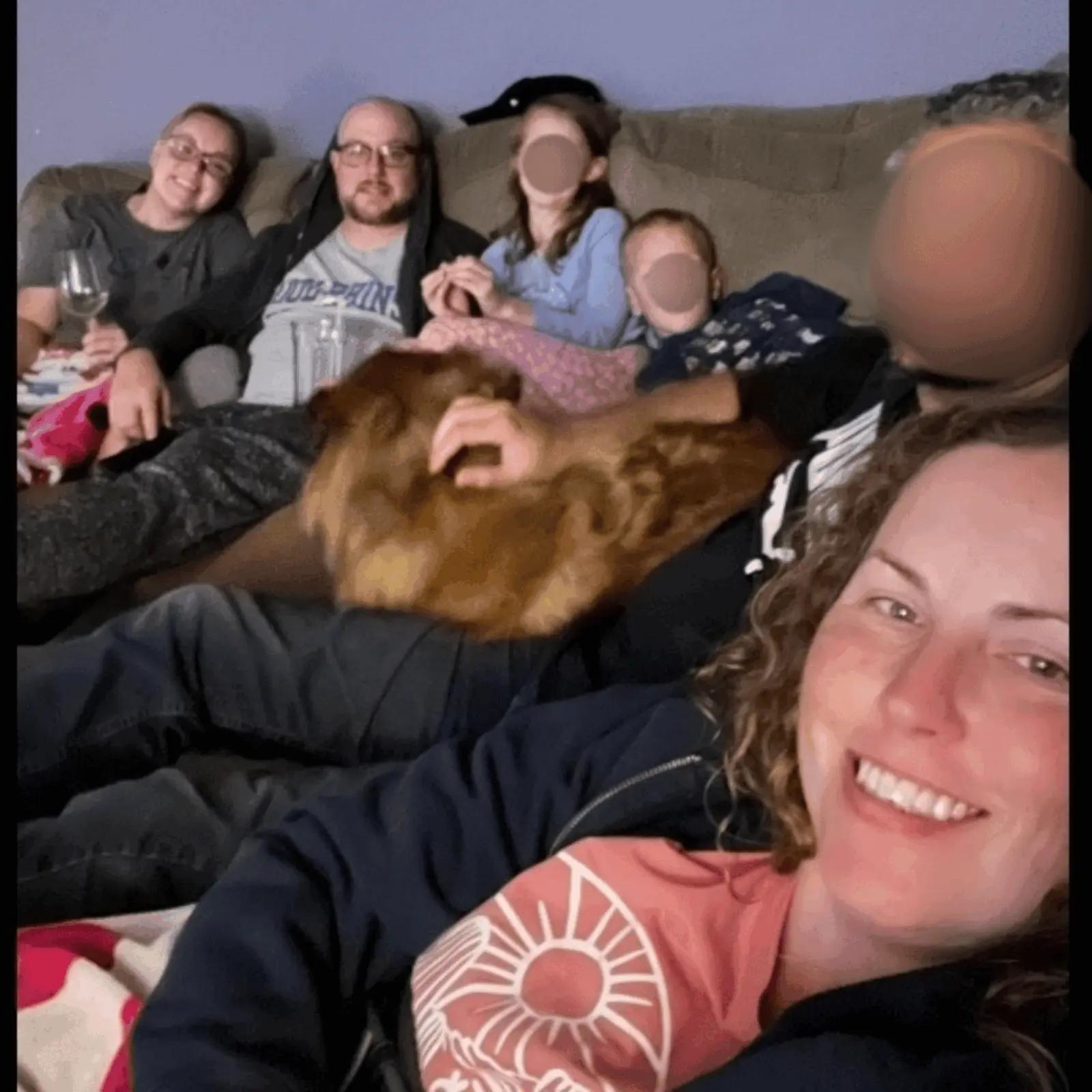 Real cozy gathering — friends on couch with dog and wine
