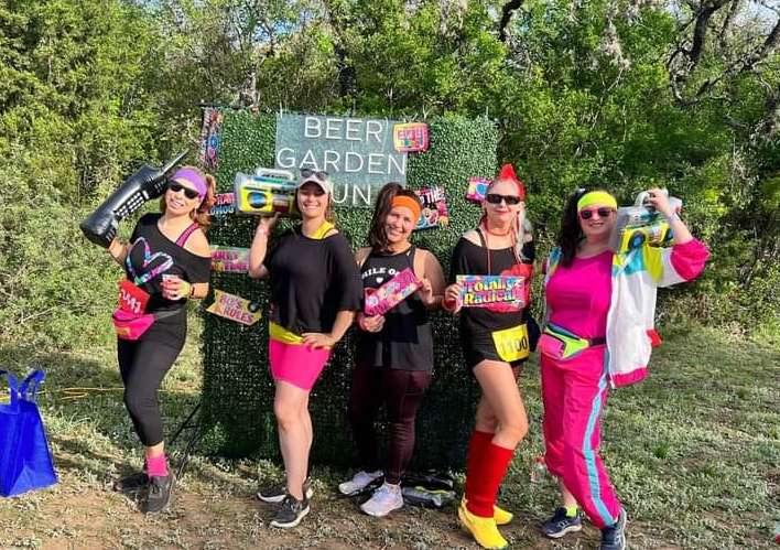 Real decades party — group in 80s neon costumes at outdoor event