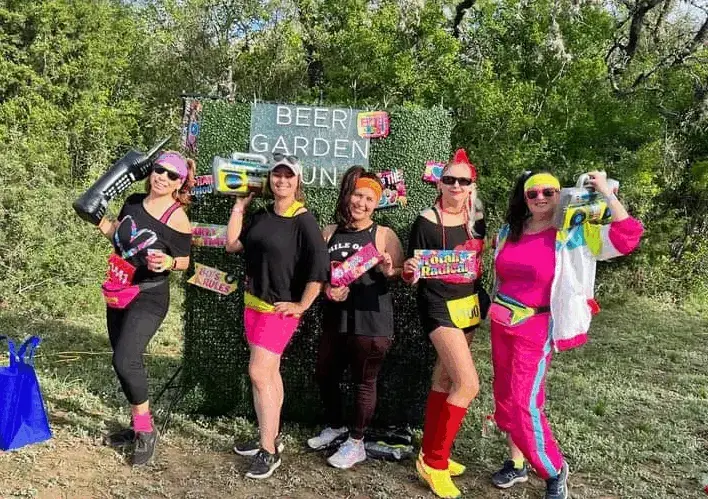 Real decades party — group in 80s neon costumes at outdoor event