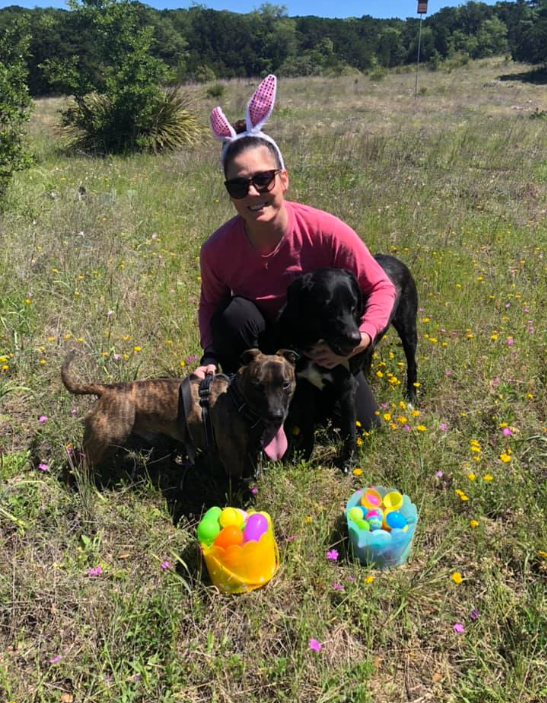Real doggy Easter egg hunt — woman with two dogs and Easter egg baskets in field