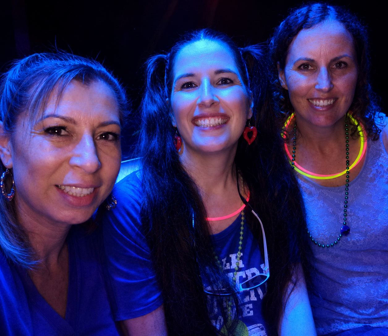 Real glow party — group selfie with neon face paint under black lights