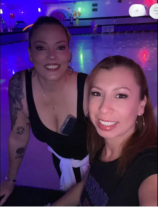 Real glow party — woman in immersive neon light room with arms raised