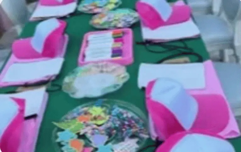 Garden party table with straw hats decorated with flowers on each chair — elegant hat party setup