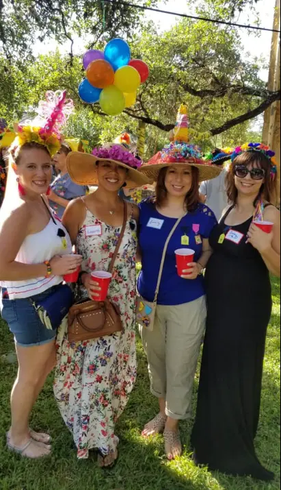 Real fun hat party — four women in creative decorated hats at outdoor gathering