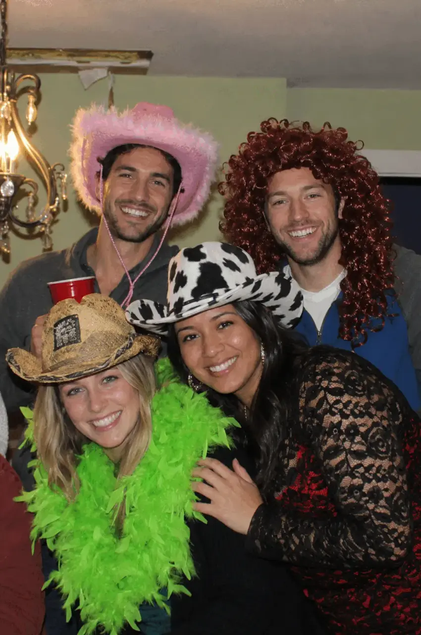 Real fun hat party — four friends in silly fun hats including pink cowboy and cow print