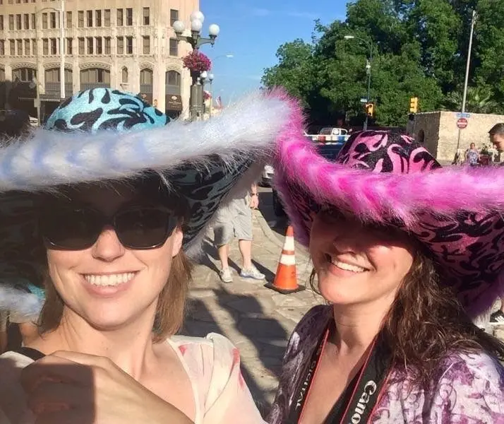 Real fun hat party — two women in elaborate feathered and sequined wide-brim hats