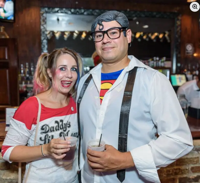 Real Heroes vs. Villains party — couple dressed as Harley Quinn and Clark Kent at a bar