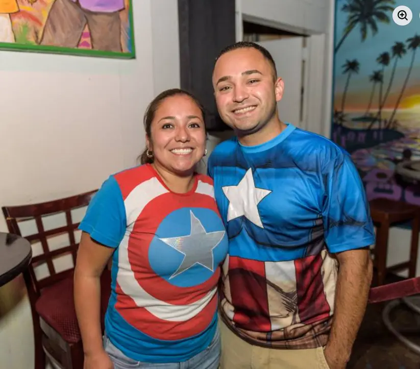 Real Heroes vs. Villains party — couple in matching Captain America shirts smiling