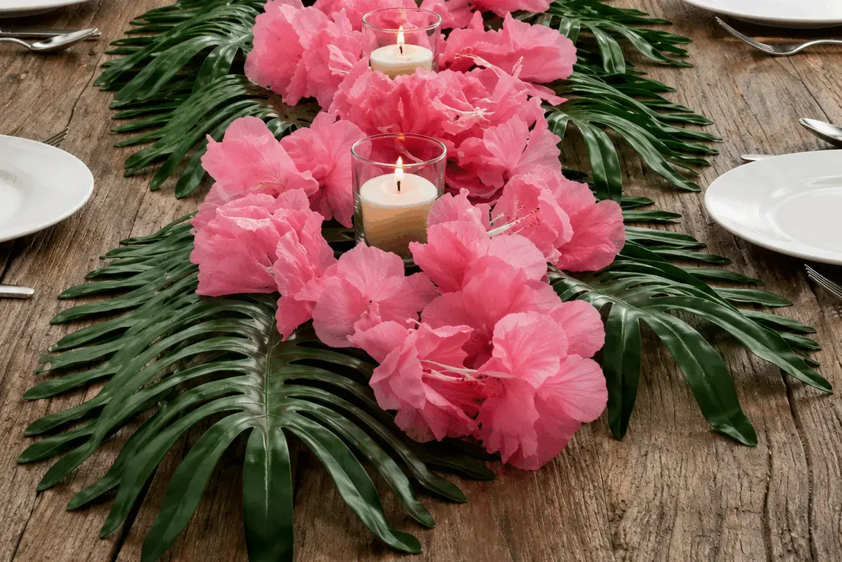 Luau party inspiration — outdoor tropical table setting with palm leaves, coconut bowls, and string lights at sunset