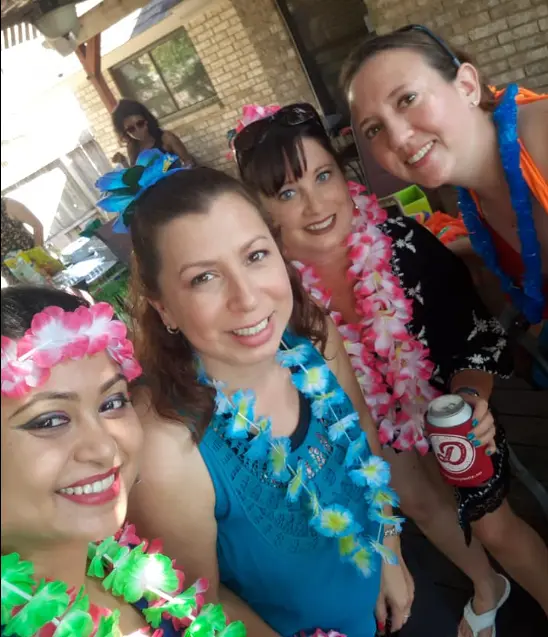 Real luau party — friends wearing colorful leis at a backyard celebration