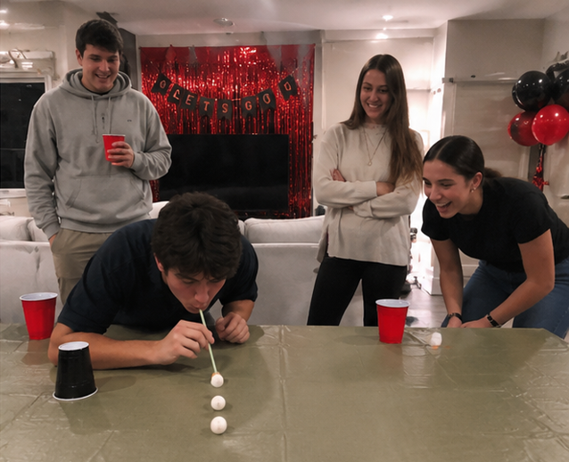 Minute to Win It party — group playing cookie stack challenge with timer