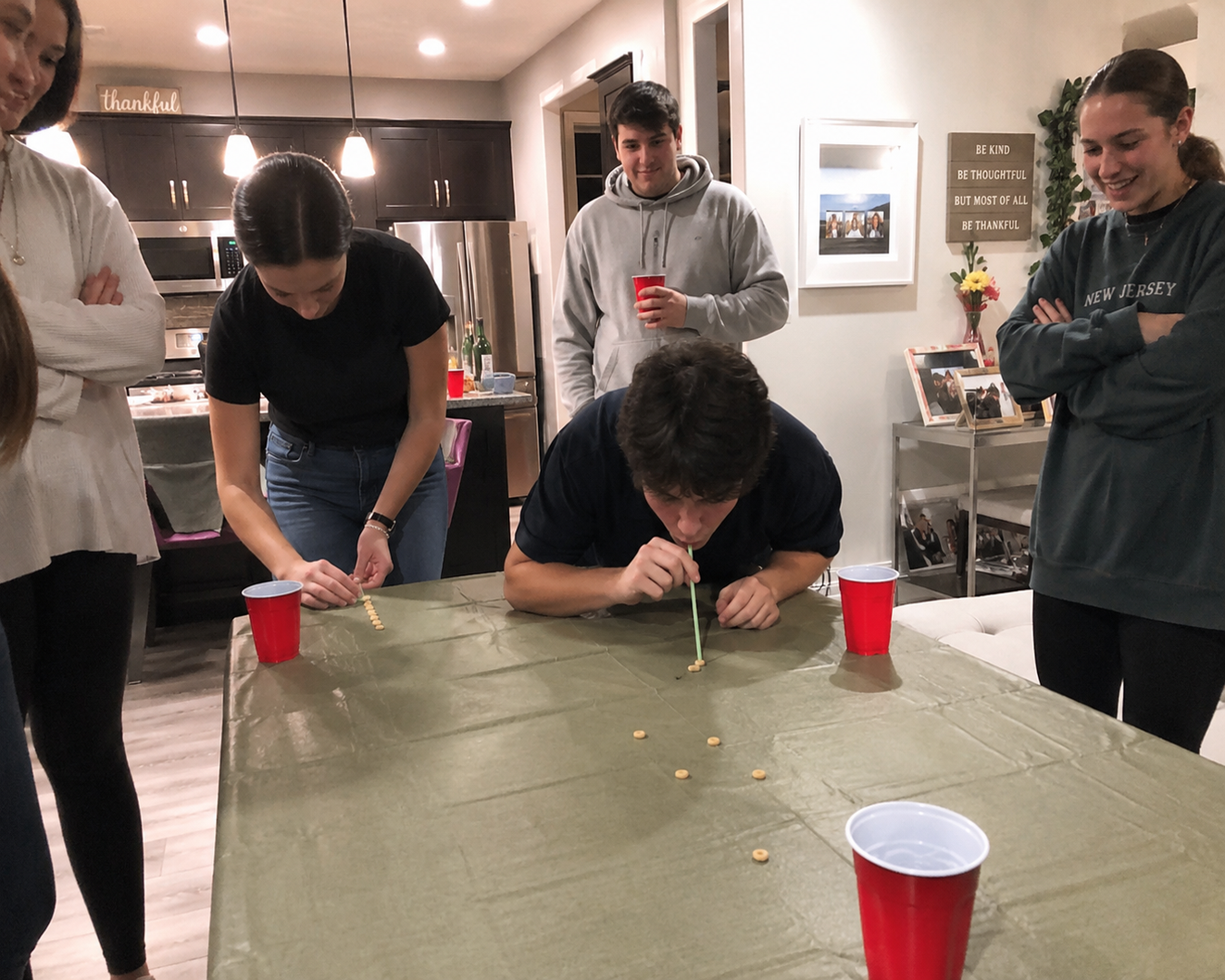 Minute to Win It party — players competing in fast-paced cup challenge with spectators cheering