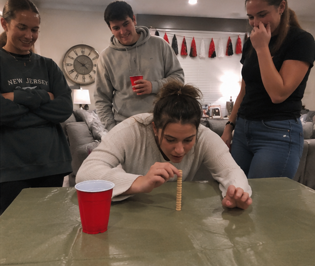 Minute to Win It party — friends celebrating a win in a colorful party room