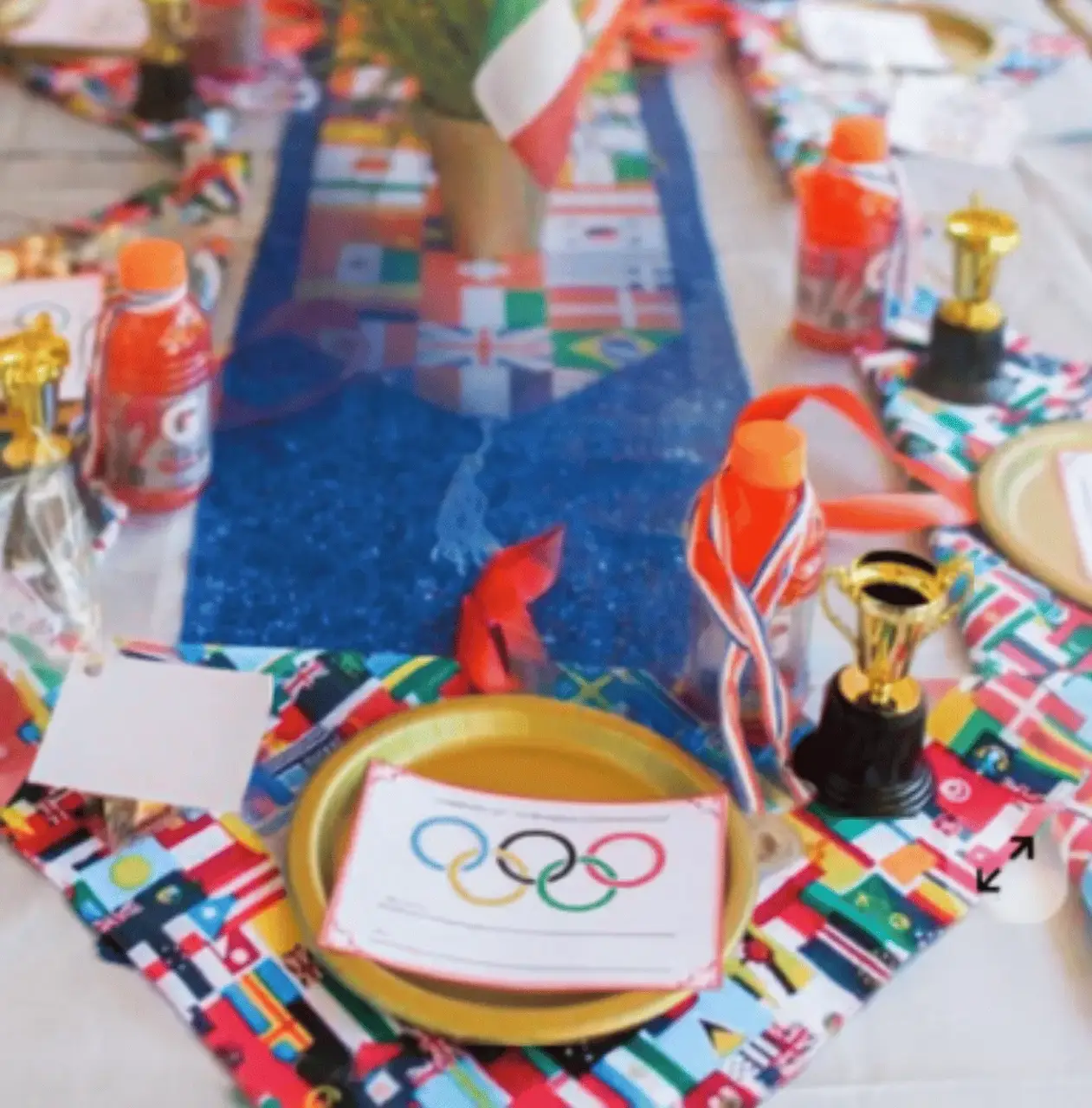 Backyard Olympics inspiration — Olympic-themed table setting with gold plates, medals and international flags