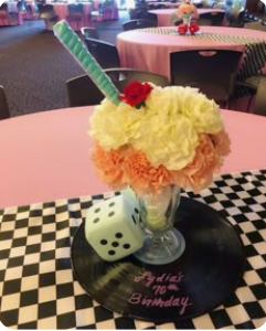 Sock Hop party — group in 50s costumes with pink Cadillac prop