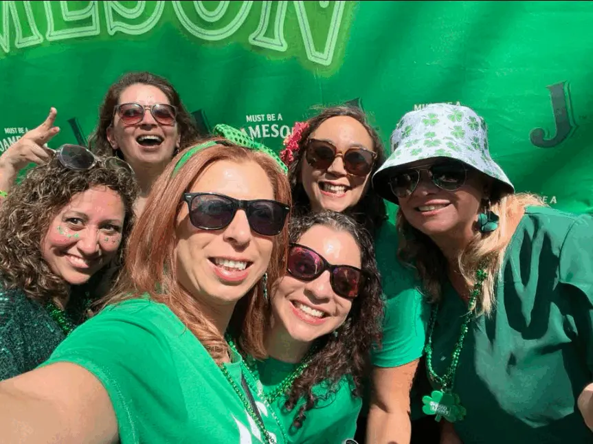 Real St. Patrick's Day celebration — friends in green with shamrock accessories and Jameson drinks