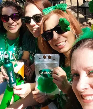 Real St. Patrick's Day celebration — two friends in green with shamrock headbands and glitter face art