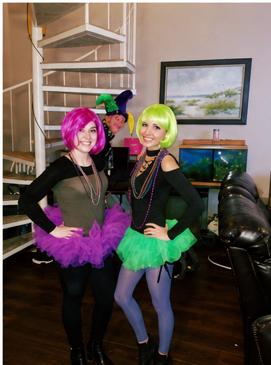 Real wig party — two women in purple and green tutus with colorful wigs